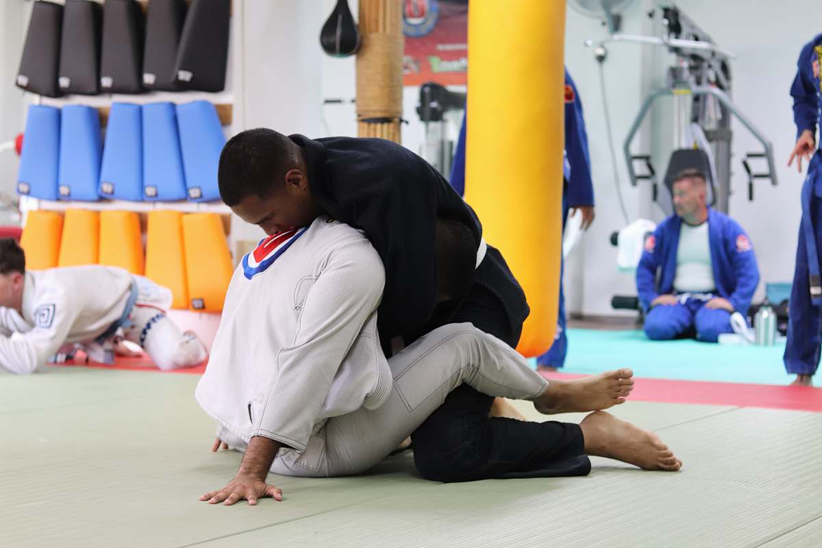 person two men perform Brazilian jiu-jitsu fitness
