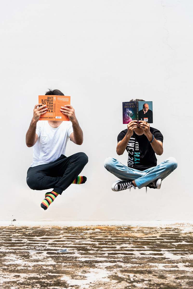 person two persons holding books shoe
