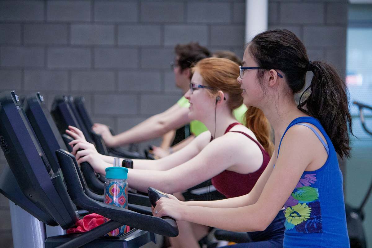 person two woman walking on treadmills people