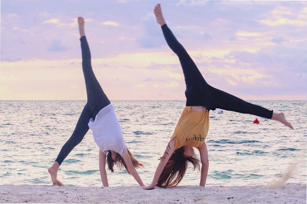 person two women on seashore during daytime working out