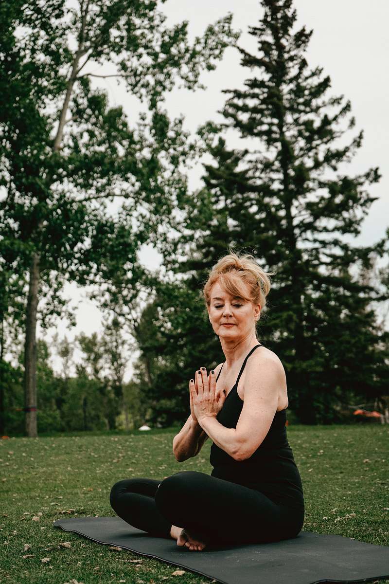 person woman doing yoga at daytime fitness