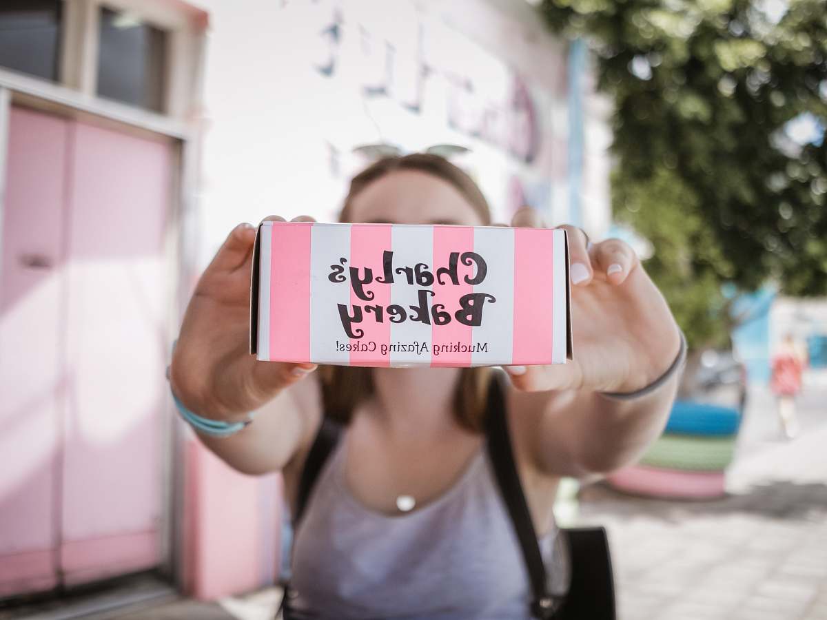 person woman holding Charly's Bakery box sports