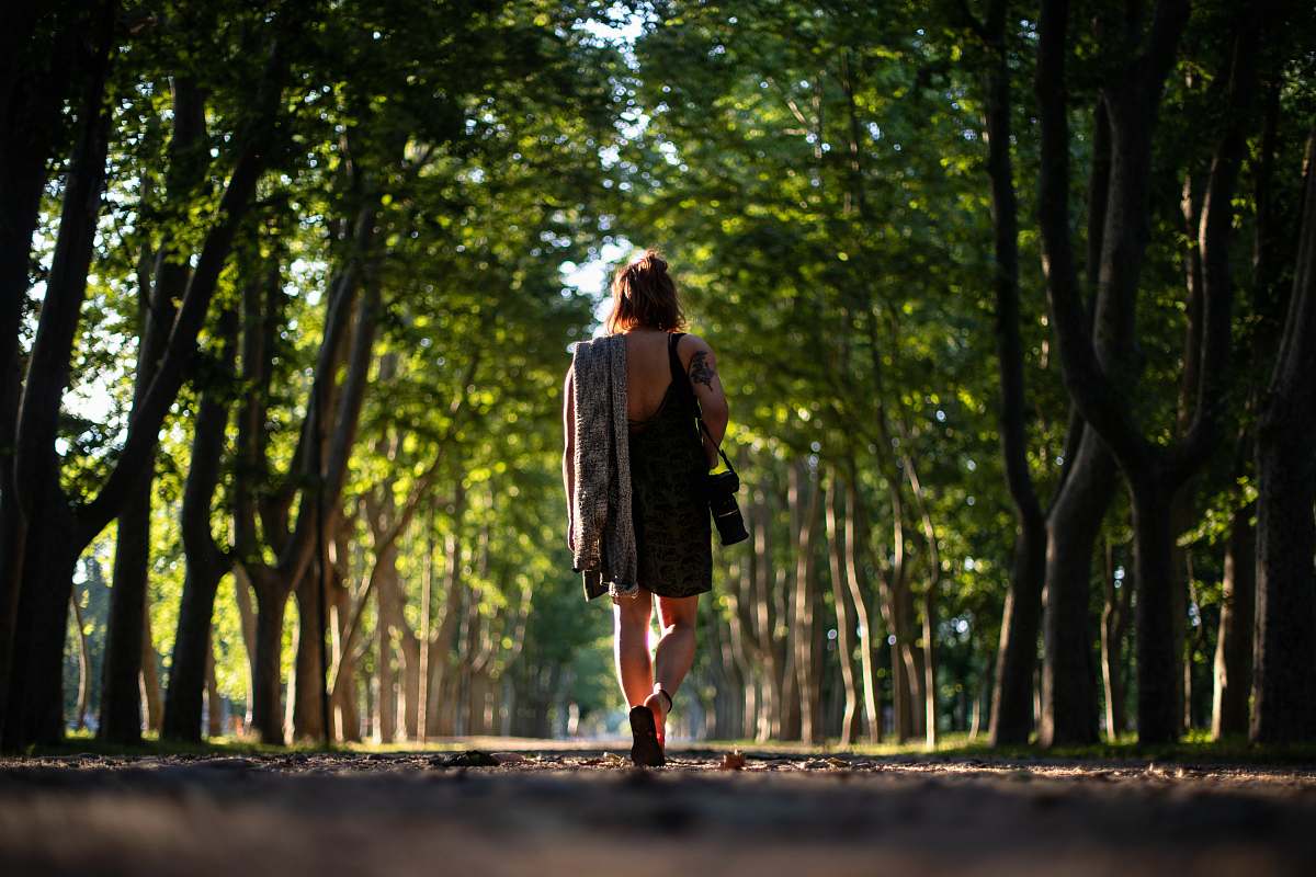 people woman in black dress carrying camera person