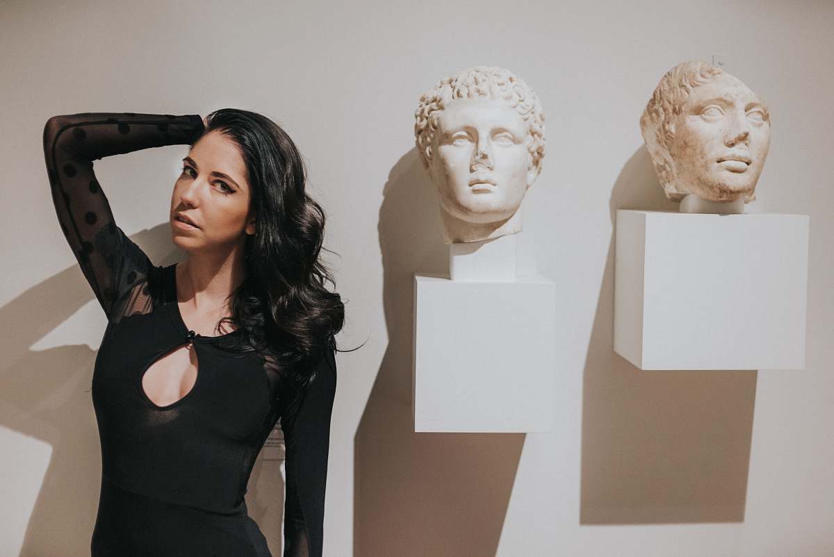 person woman in black dress near wall art