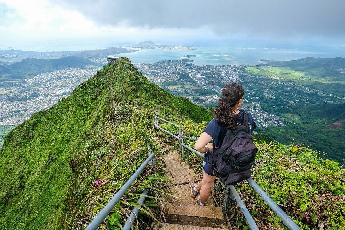 Capture the spirit of adventure with this stunning image of an outdoors woman dressed in a black shirt, confidently walking up a steep mountain staircase. This captivating scene showcases the beauty of nature and the determination of individuals who embrace outdoor challenges. Perfect for travel blogs, adventure sports articles, or motivational content, this image reflects the essence of exploration and the joy of conquering natural landscapes.