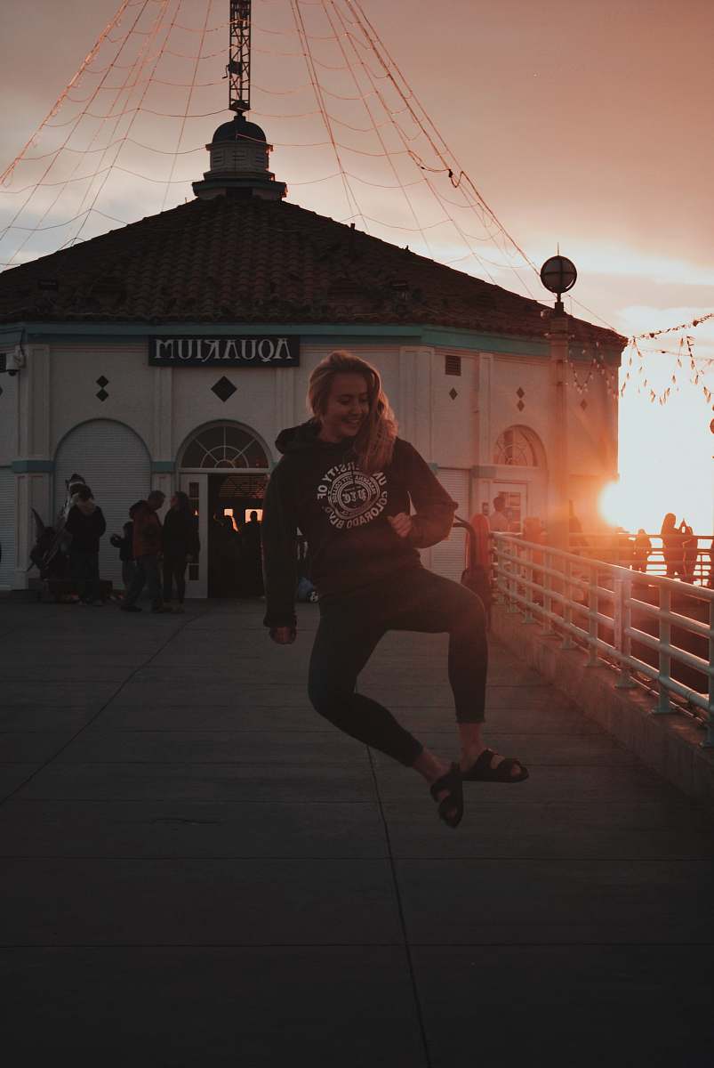 flare woman jumping in front of Aquakjuim building light