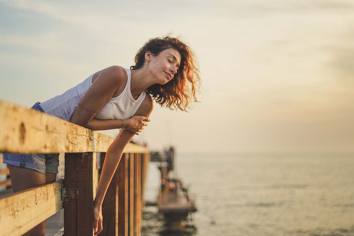 person woman leaning forward on dock rail pier