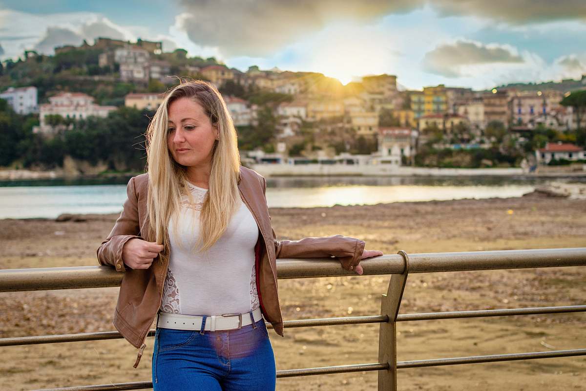 person woman leaning on bridge rail in front of buildings people