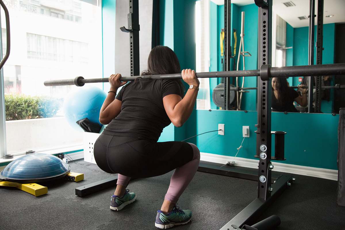 person woman lifting barbel rod sport