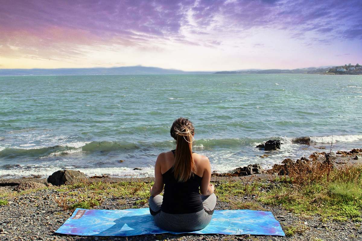 person woman meditating at beach exercise