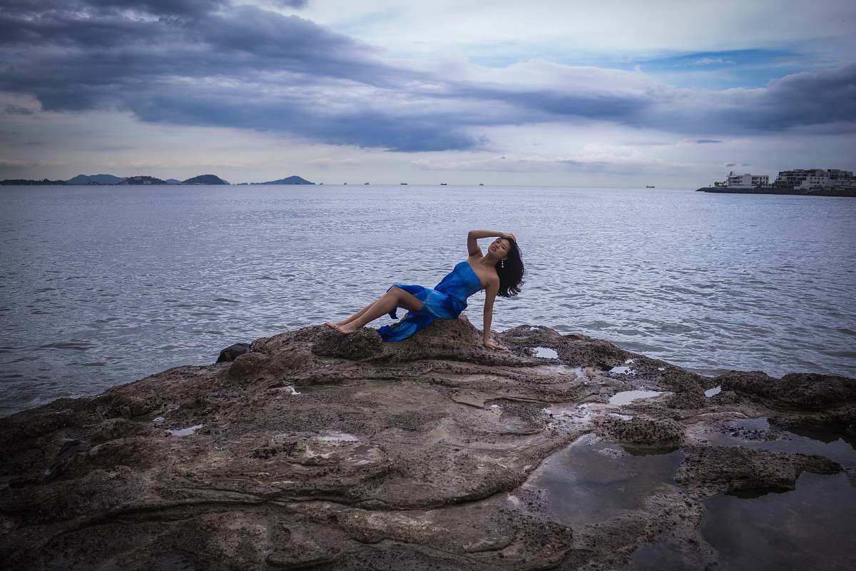 person woman sitting on rock fragment exercise
