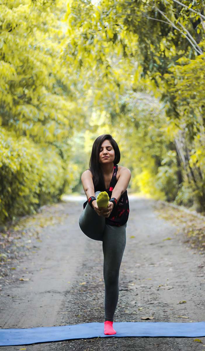 person woman standing and doing yoga vegetation
