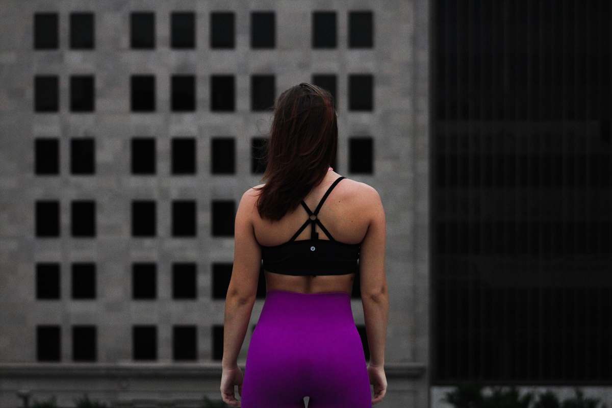 person woman standing in front of gray building during daytime people