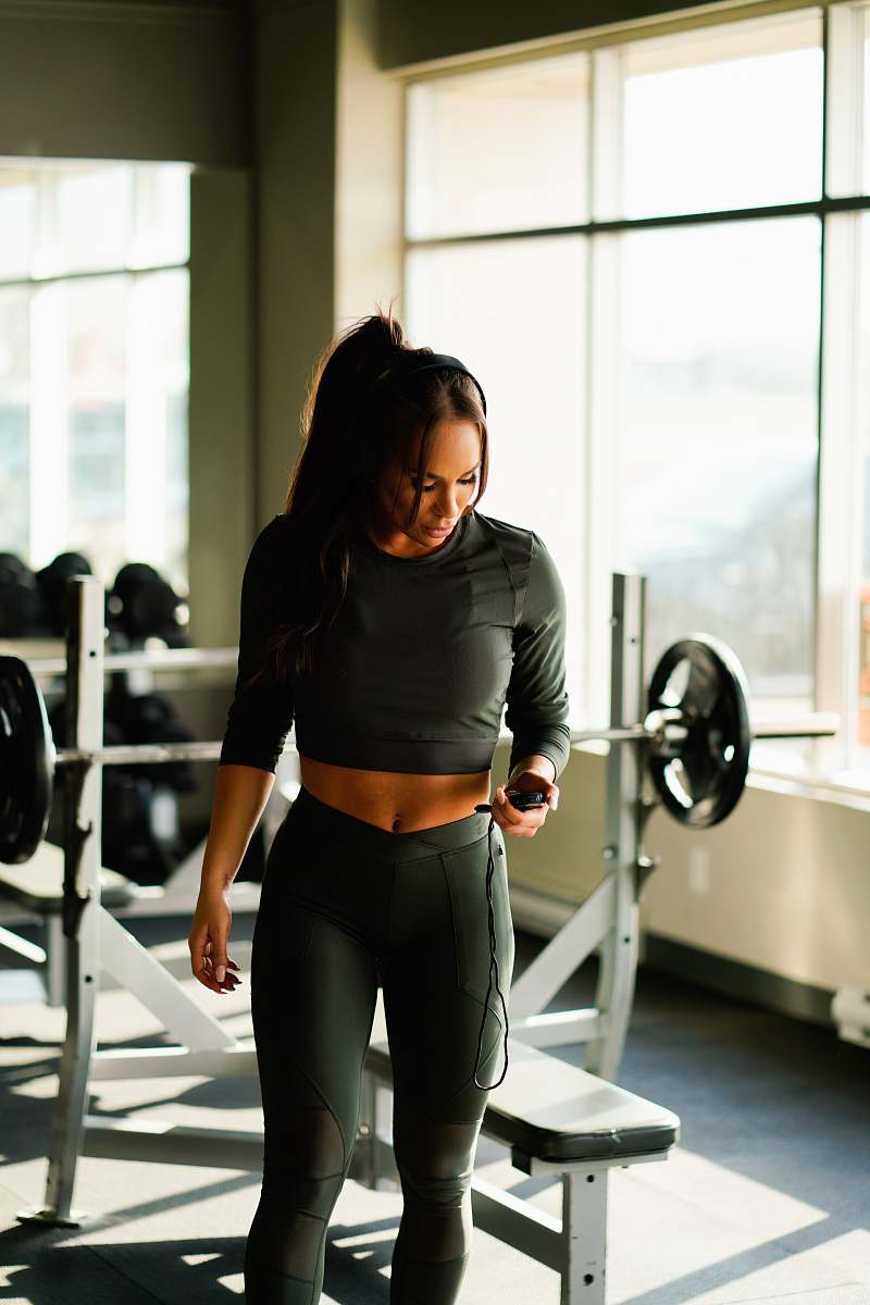 person woman standing near weight bench near window inside gym during daytime fitness