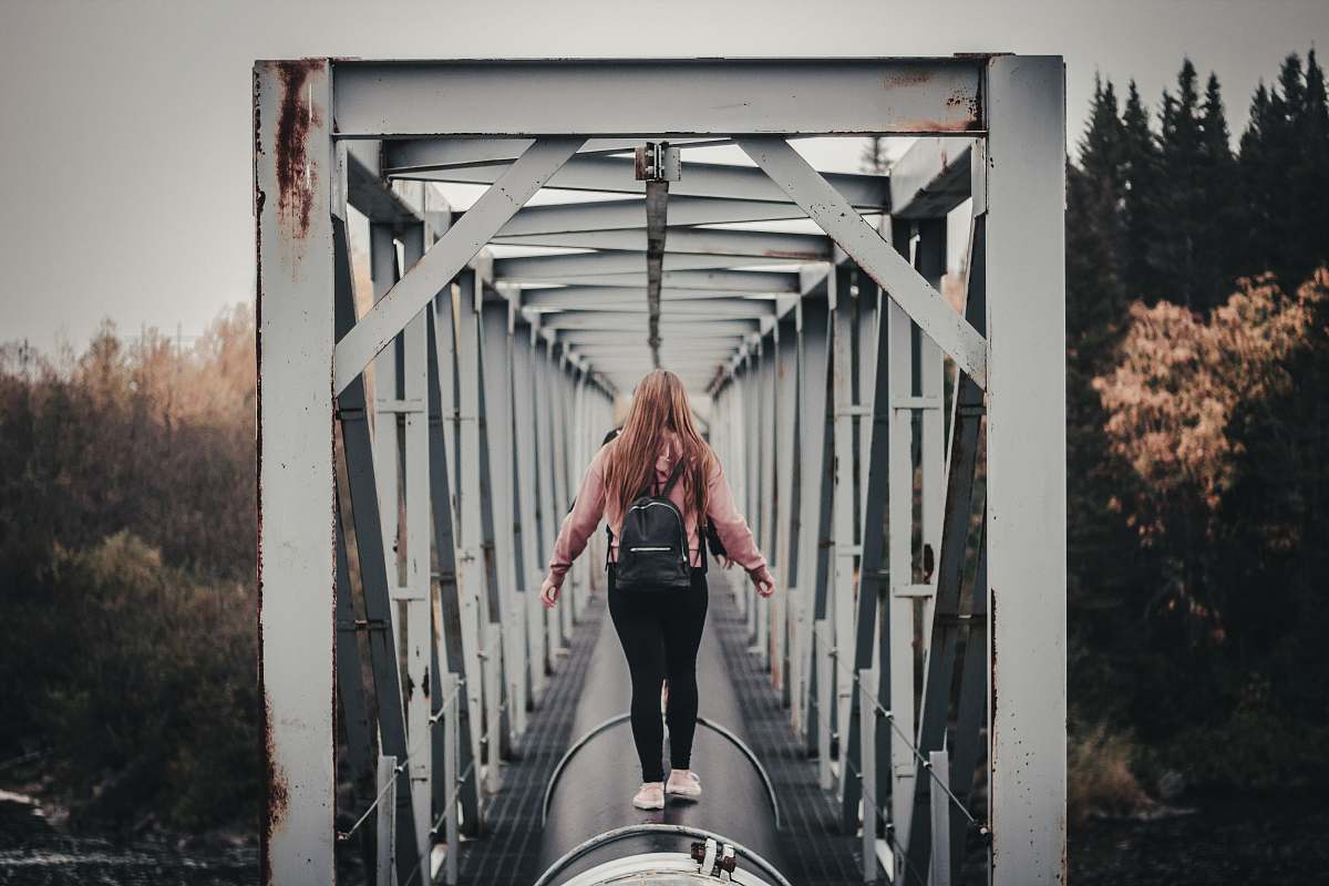 person woman standing on black tunnel at daytime people