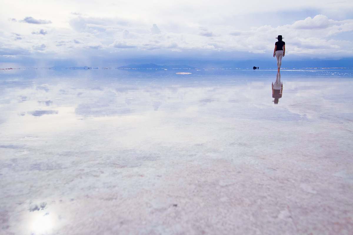 Capture the serene beauty of nature with this stunning image of a woman standing confidently on a vast expanse of water during daylight. This enchanting scene embodies tranquility and freedom, making it perfect for projects related to wellness, nature, or personal empowerment. Ideal for use in promotional materials, blogs, or social media posts that celebrate connection with nature and self-discovery.