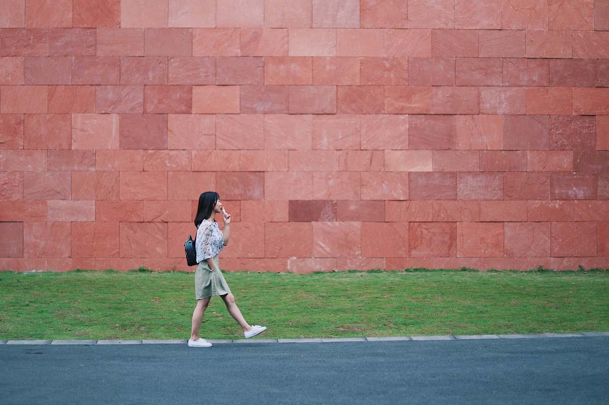 person woman walking on asphalt road people