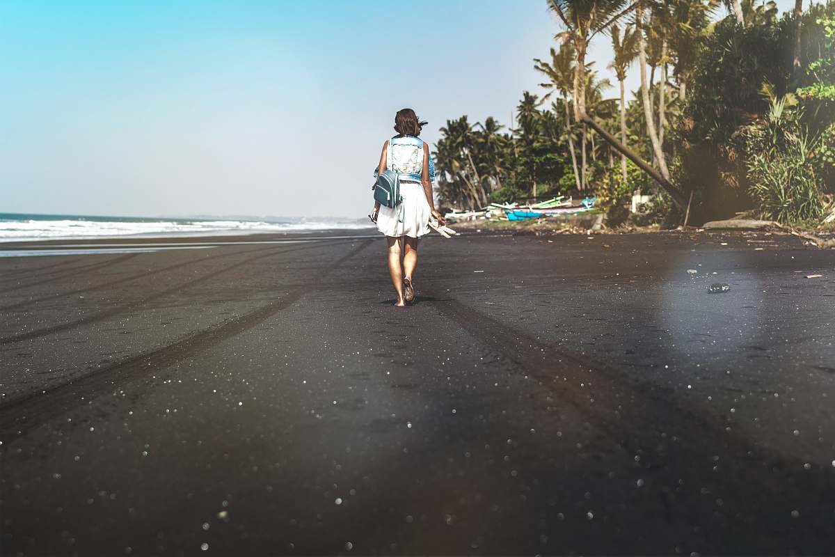 people woman walking on seashore near palm trees person