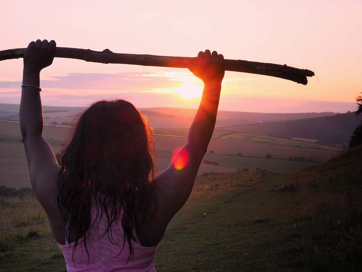 person woman wearing pink tank top holding wood stick during sunrise people