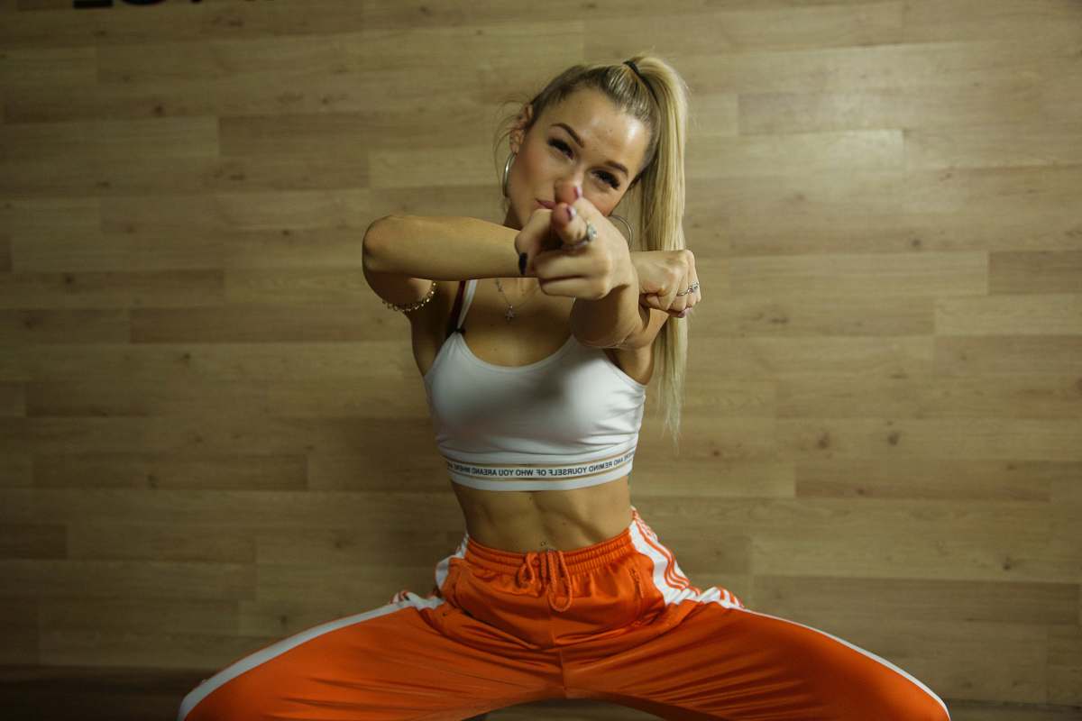 person woman wearing white and orange tracksuit set pointing her finger exercise