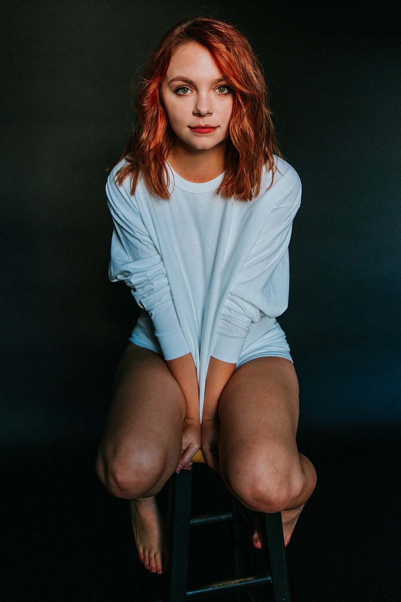 people woman wearing white long-sleeved shirt sitting on chair person