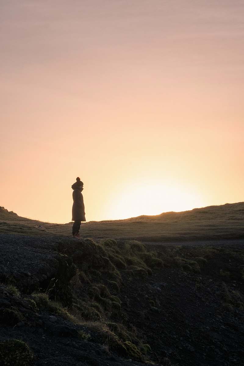 mountain silhouette of person standing on hill during golden hour hill