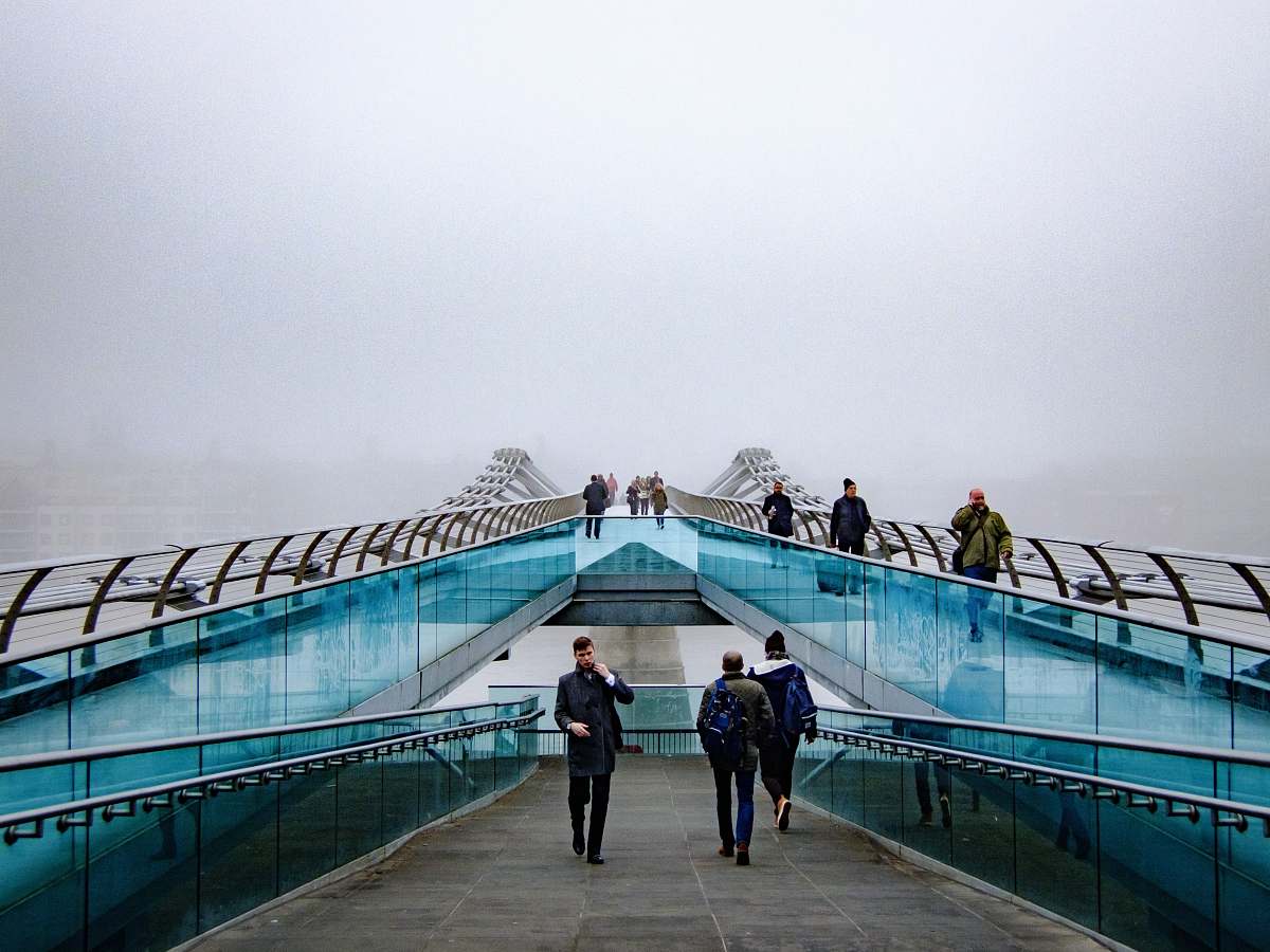 blue people walking near glass railings millennium bridge
