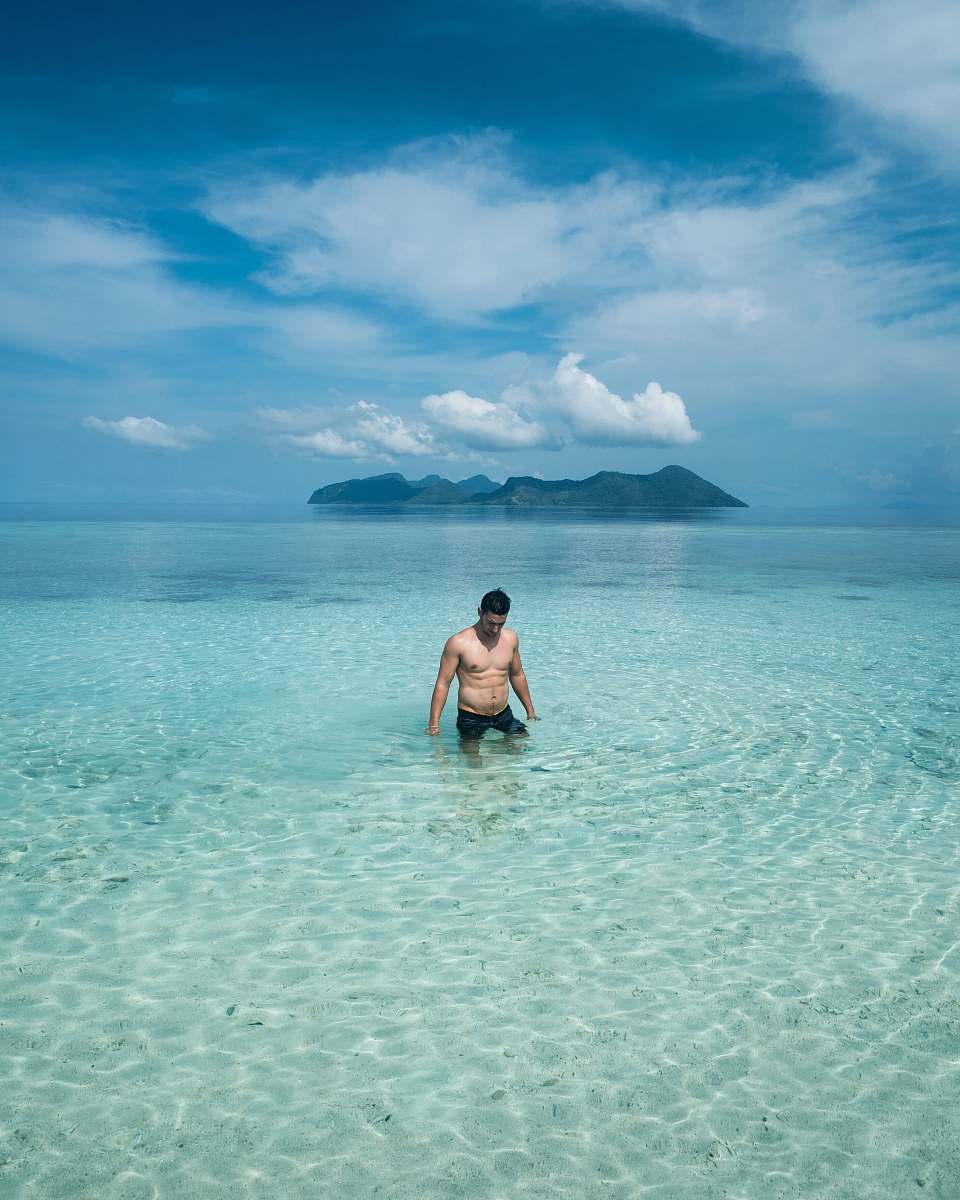 outdoors man in black shorts on blue sea land