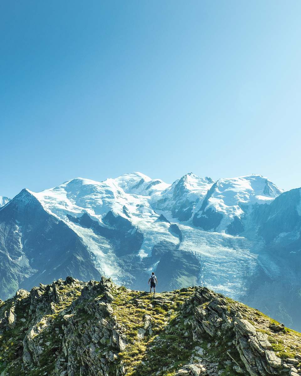 mountain man standing overlooking mountain at daytime outdoors