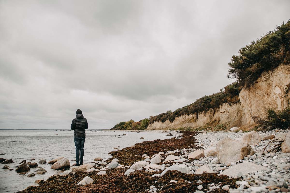 coast person standing on seashore ocean