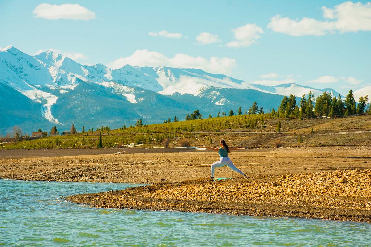 outdoors woman doing yoga near river mountain