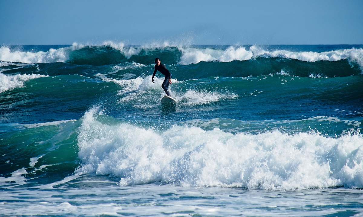 sea person surfing during daytime water