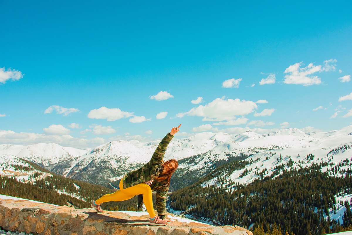 nature woman performing yoga on cliff mountain