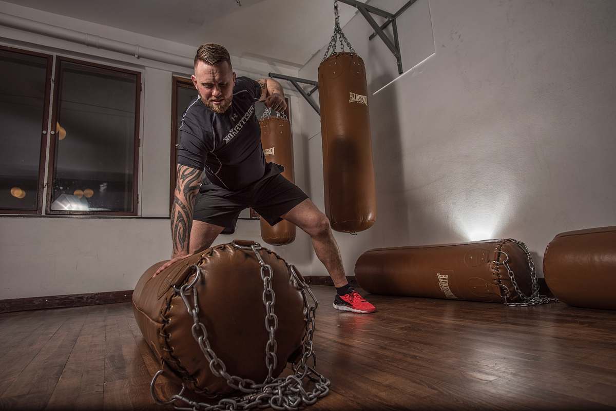 human man punching brown leather heavy bag person
