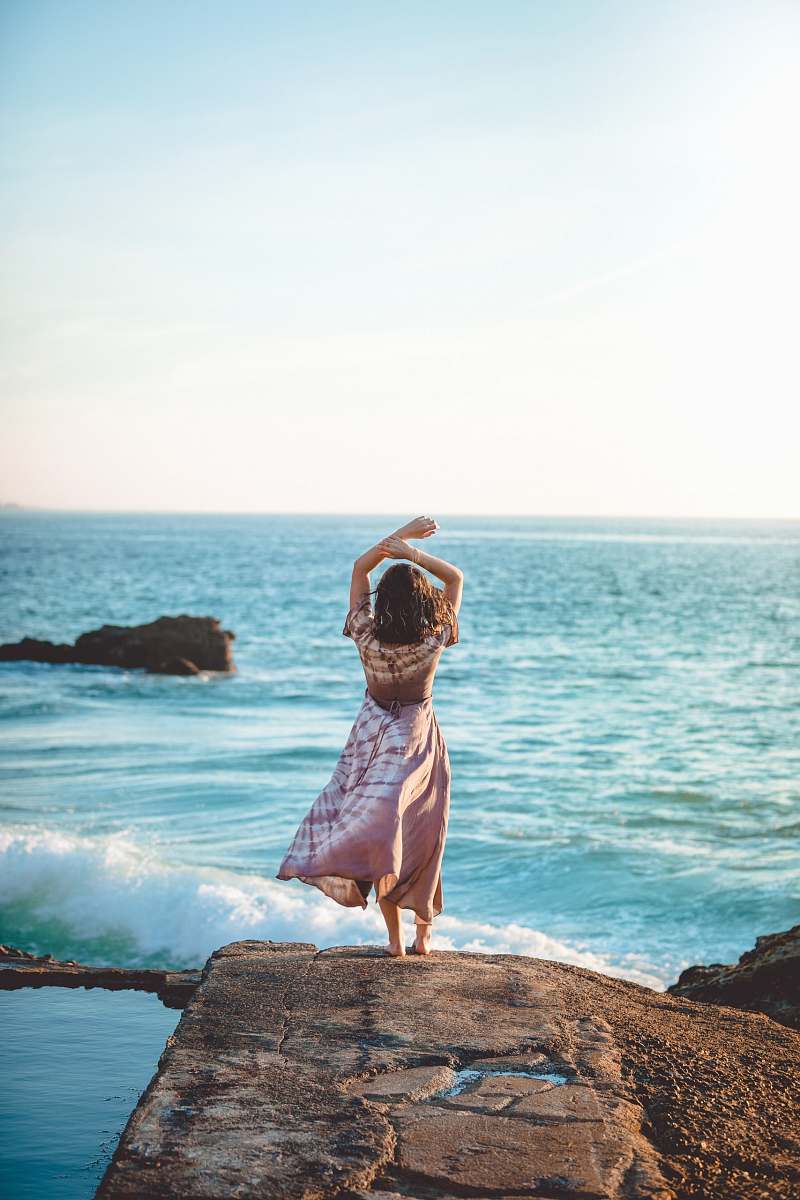 person woman standing on cliff raiser her hands human