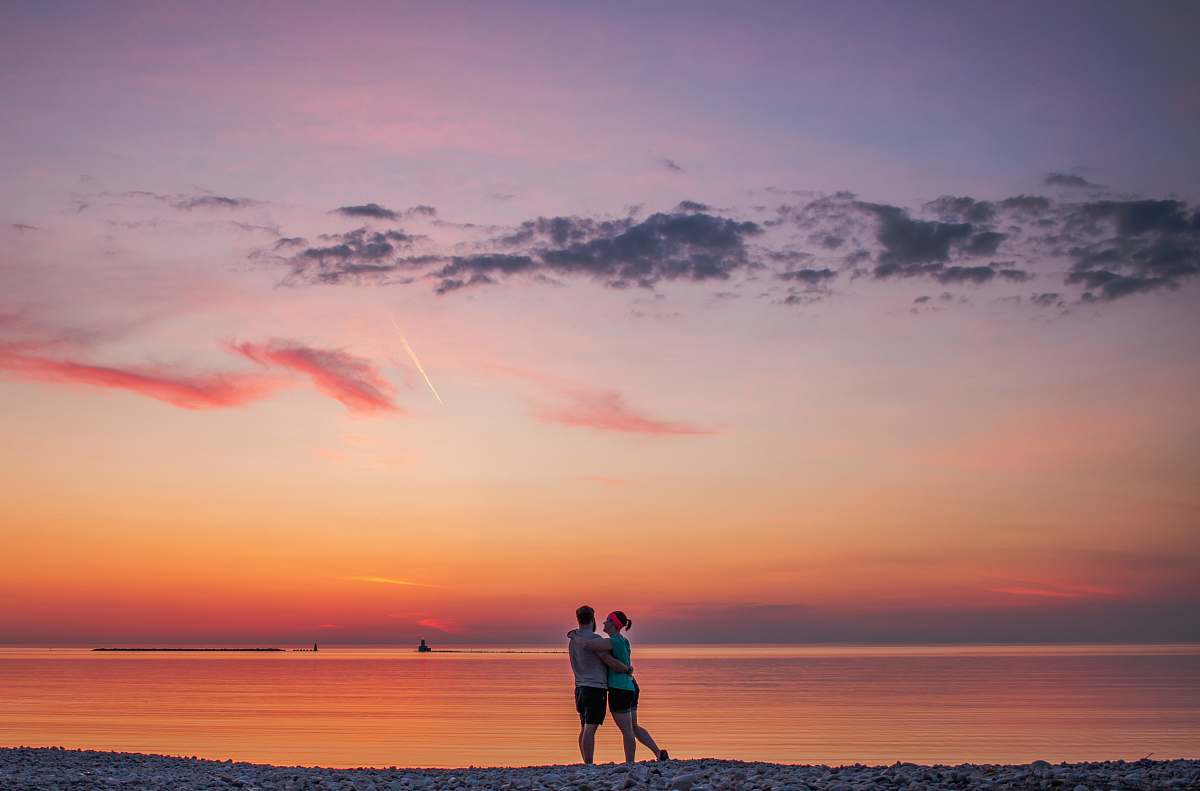 human couple hugging each other near seashore people
