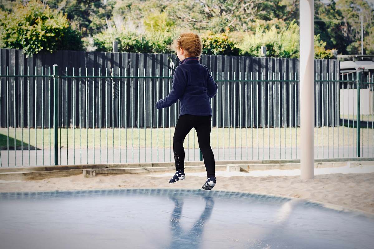 human girl in blue sweater jumping shoe