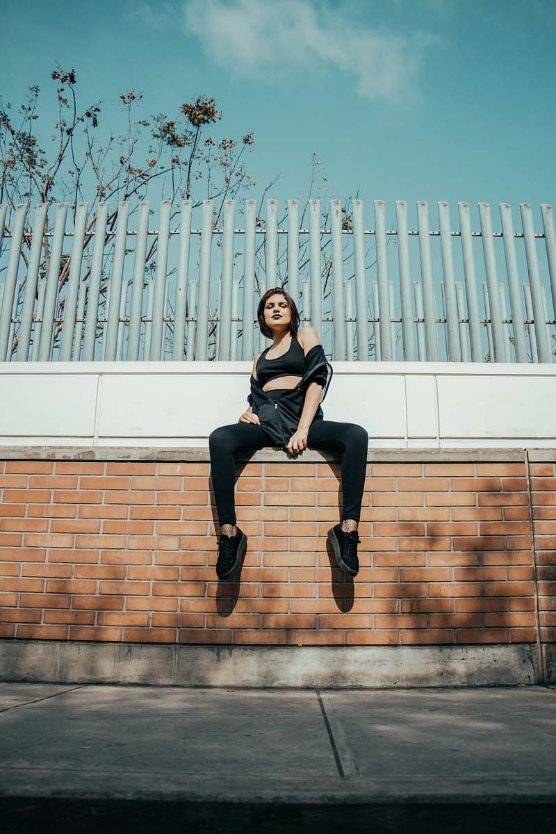 human girl sitting on brown concrete wall people