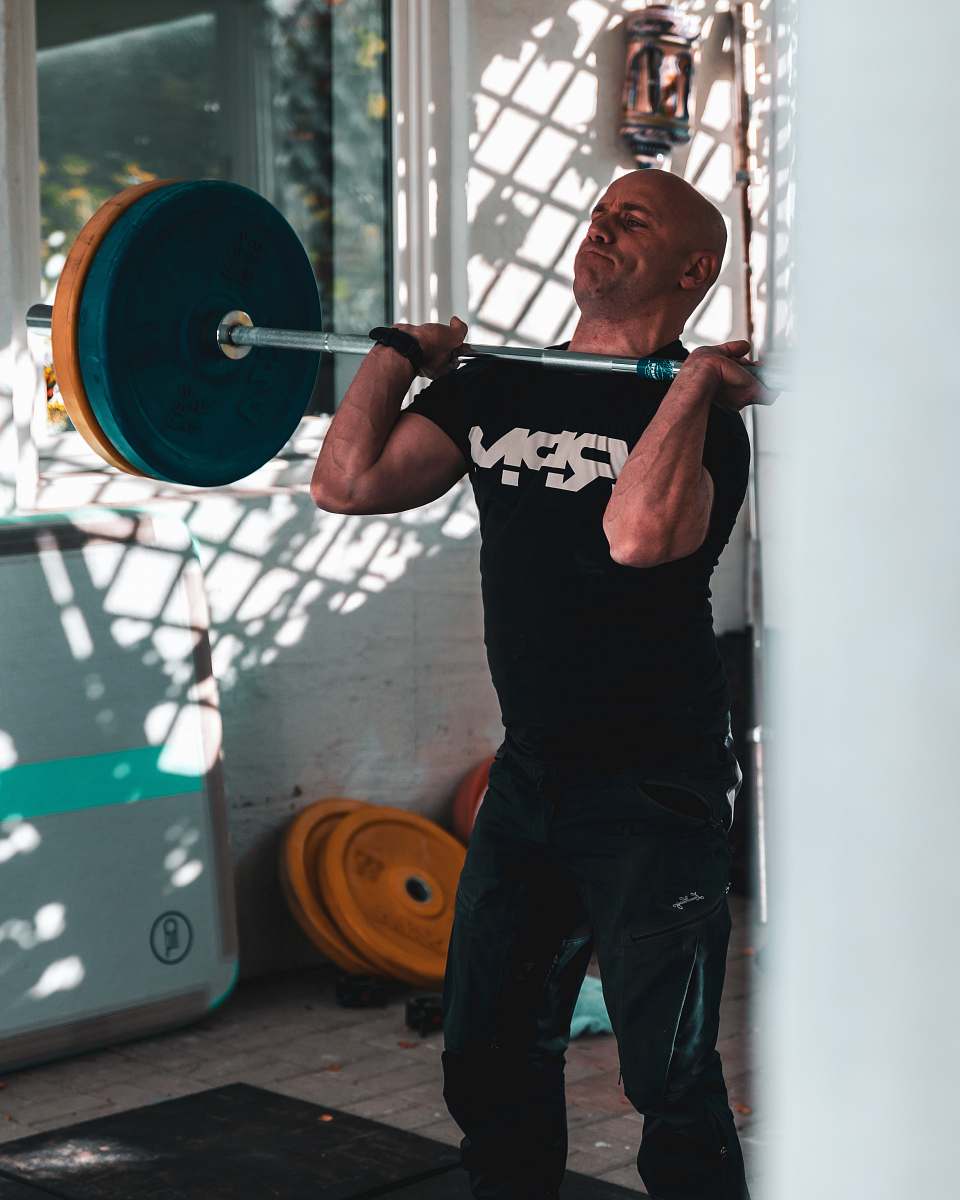 human man carrying barbell working out