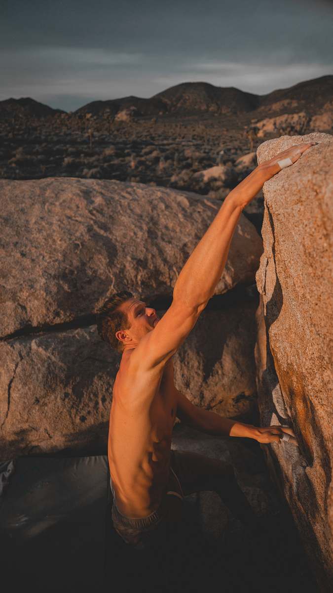 human man climbing rock outdoors