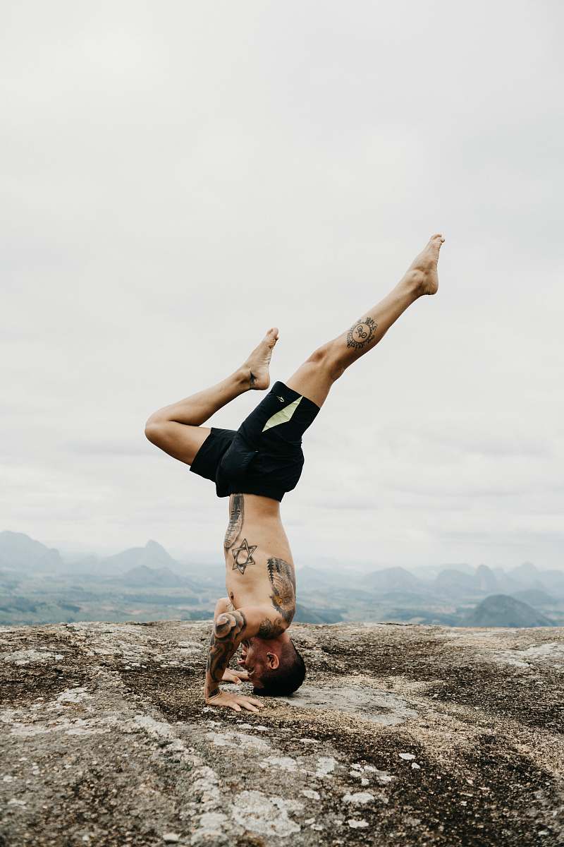 human man doing hand stand yoga