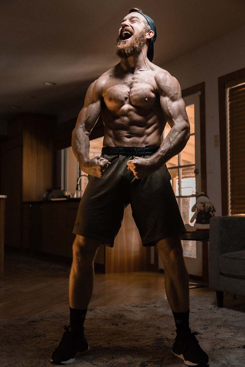 human man flexing muscles wood