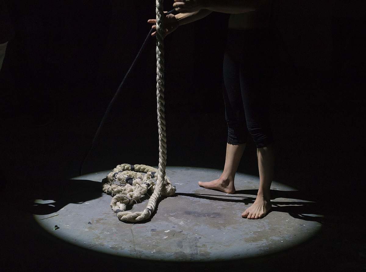 rope man holding brown rope darkness