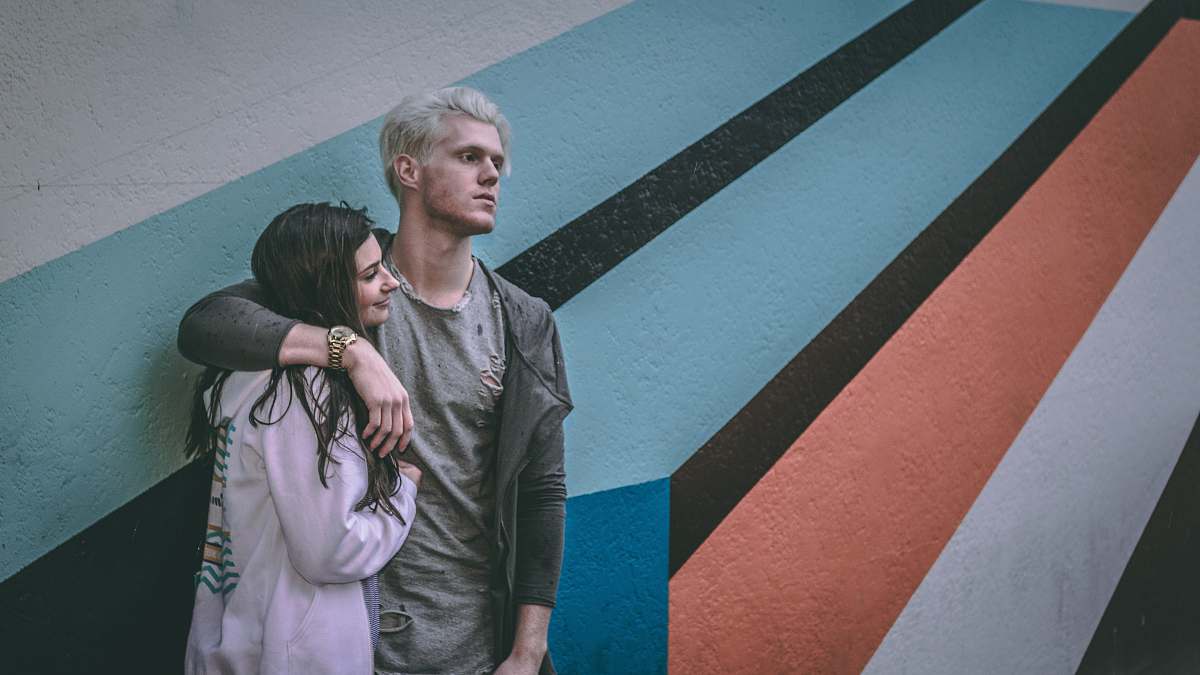 human man holding shoulder of woman tarmac