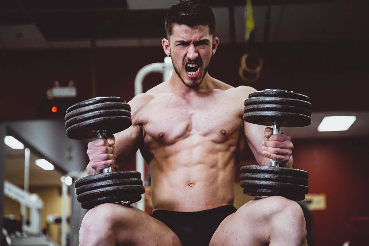 human man holding two dumbbells people