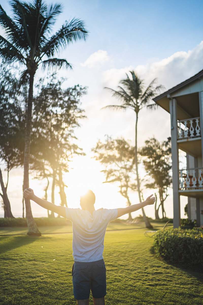 people man in white shirt standing while raising hands near house human