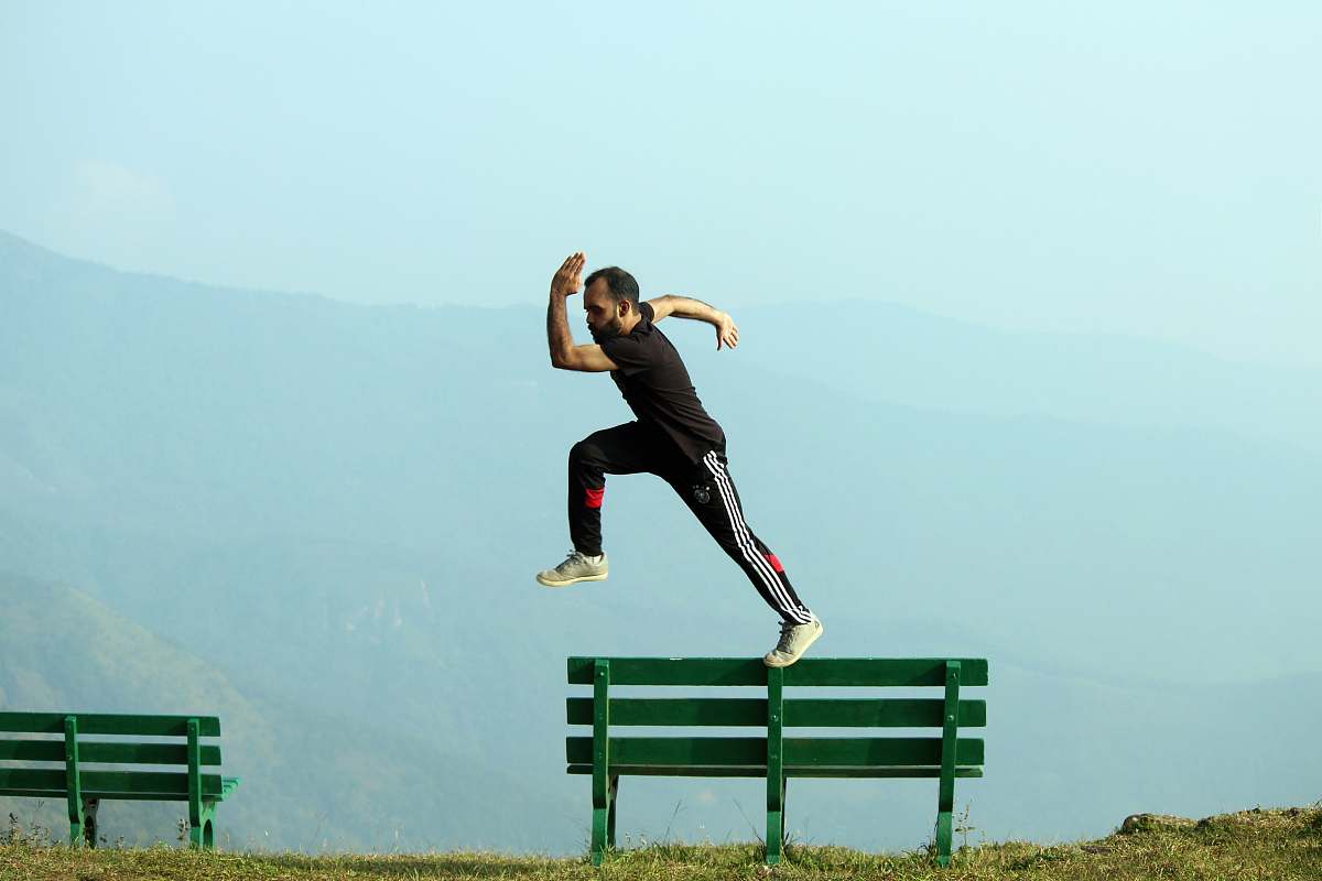 furniture man jumping beside bench bench