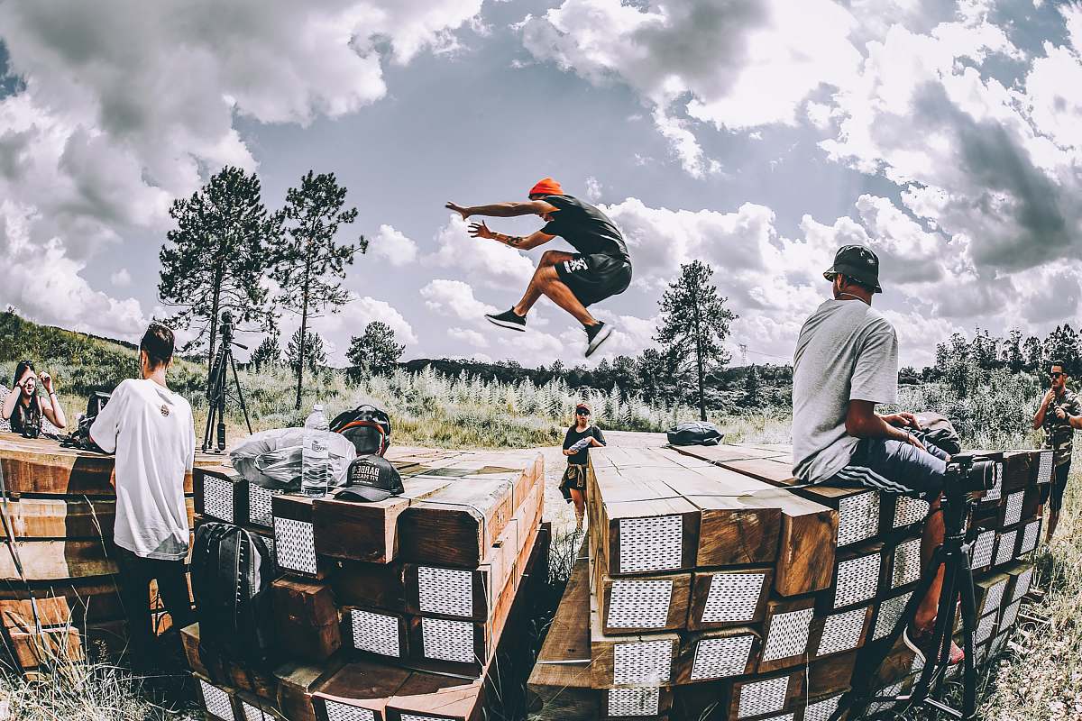 human man leaping on brown wooden platform people