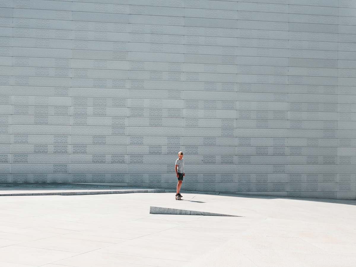 human man playing with skateboard wall