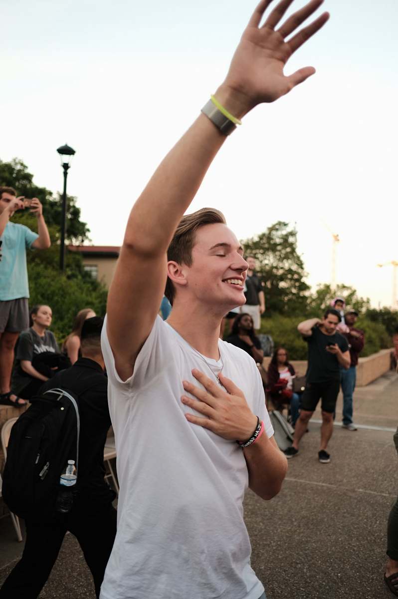 human man raising his left hand apparel